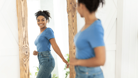 Woman smiling back at herself in mirror