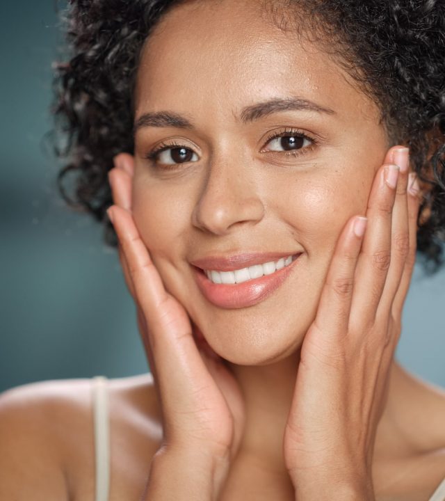 Female Beauty Portrait. Beautiful Black Multiethnic Latina Woman with Afro Hair Posing, Touching Her Natural, Healthy Skin. Wellness and Skincare Concept on Soft Isolated Background. Close Up.